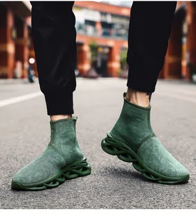 Dettaglio delle sneakers a calzino verde scuro con suole ondulate cave dal design unico