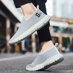 Graue Herren-Slipper aus atmungsaktivem Mesh mit dicker weißer Sohle in urbaner Umgebung