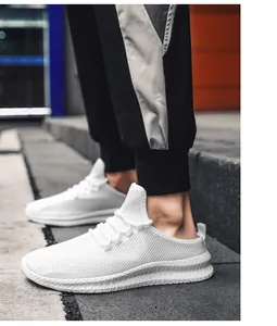 Nahaufnahme weißer atmungsaktiver Mesh-Sneaker mit Wellensohle auf Stadttreppen