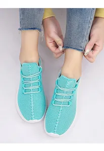 Close-up of mint green breathable mesh sneakers with white lightweight soles on feet