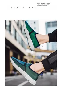 Close-up van lichte slip-on hardloopschoenen met blauw-groen mesh en een witte zool