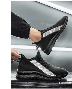 On-foot shot of black breathable mesh running sneakers with stylish side tape detail