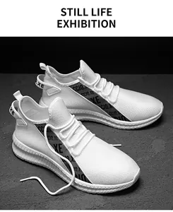 Detail view of white breathable mesh sneaker showing side letter tape and thick sole