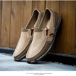 Detail of khaki slip-on canvas shoes featuring contrast white stitching and textured sole