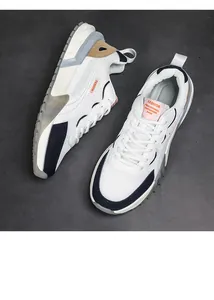 Vue de dessus détaillée de baskets blanches à empiècements en mesh bleu et marron et semelles épaisses