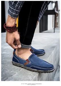 Detail view of denim blue slip-on canvas shoes with white stitching for casual wear