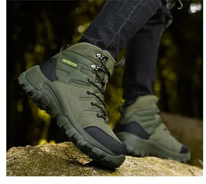 Primo piano di scarponi da trekking verde militare con suole in gomma su rocce