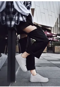 Scatto street style di sneakers basse in pelle bianca abbinate a pantaloni cargo neri