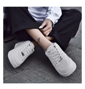 Vista dall'alto di sneakers casual in pelle bianca con classiche suole spesse piatte e lacci