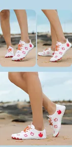 Detail of white water shoes with red maple leaf print and orange elastic toggle laces