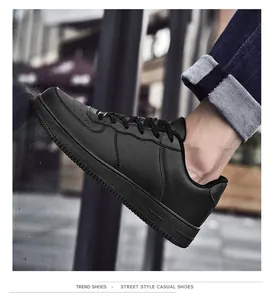 Vista street-style di sneaker in pelle nera opaca con punta traforata e suola spessa