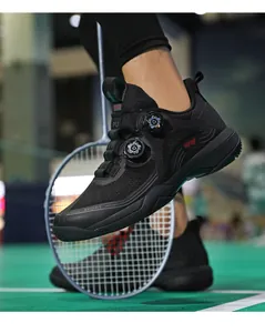 Detail von schwarzen Badmintonschuhen mit Doppel-Drehverschluss auf grünem Hallenboden