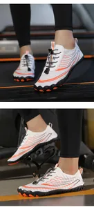 Λεπτομέρεια από λευκά παπούτσια barefoot με πορτοκαλί τόνους και αντιολισθητική σόλα