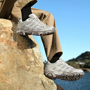 Chaussures de randonnée grises respirantes avec semelle en caoutchouc sur rochers