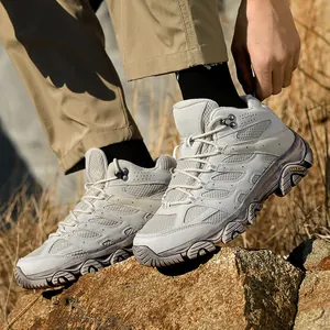 Hiking boots on rocky terrain, light gray outdoor shoes with non-slip thick soles