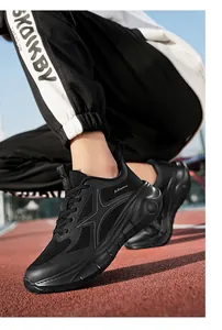 Nahaufnahme schwarzer Laufschuhe mit dicker Dämpfungssohle auf einer Rennbahn