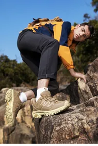 Detalle de botas de senderismo de caña alta con suela de goma robusta en escalada al aire libre
