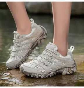 Détail de chaussure de randonnée sur rochers mouillés avec maille respirante et semelle épaisse