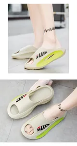 Detail of chunky EVA slide with beige base, neon green accents and SUP lettering logo
