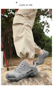 Close-up of gray outdoor hiking boots on rocks with anti-slip rubber soles and mesh upper