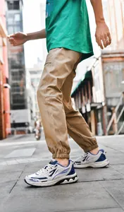 Outdoor street view of casual khaki cargo joggers paired with white and blue sneakers