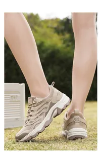 Outdoor shot of beige and khaki winter boots showing thick durable sole on grass