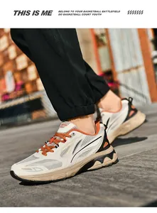 Close-up of stylish retro sneakers with cream mesh panels and orange lace details