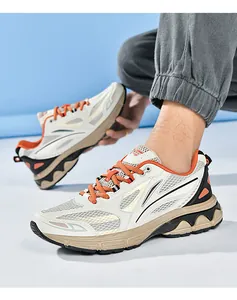 Detailed close-up of chunky sneakers with mesh panels and vibrant orange laces
