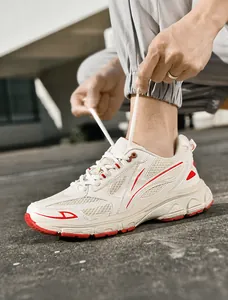 Close-up of stylish off-white and red mesh sneakers with white laces for outdoor wear