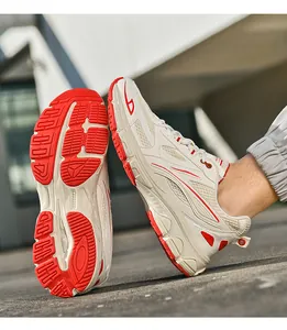 Detailed side view showing red rubber anti-slip sole and mesh texture of chunky sneakers