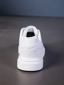 Detalle del talón de la zapatilla blanca con costuras en V y suela gruesa