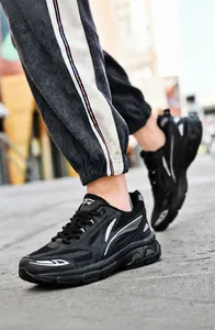 Detailed shot of black casual sneakers with silver stripes and breathable mesh upper