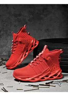 Detail of red high-top safety shoes with steel toe and wave texture soles on concrete