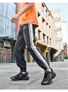 Detail of grey corduroy joggers with side stripe and logo for street casual look