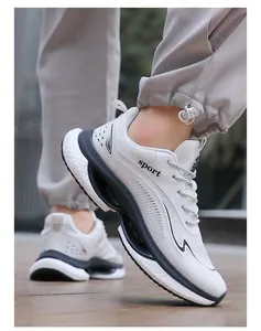 On-foot shot of white and blue lightweight breathable sneakers with sport lettering