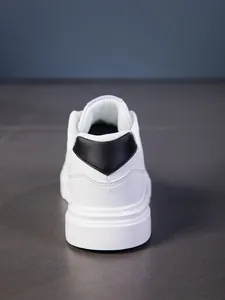 Vista trasera de zapatillas blancas de cuero con detalle negro en talón y suela gruesa