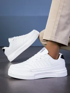Vista lateral macro de zapatillas blancas casuales con perforaciones y detalle negro en talón