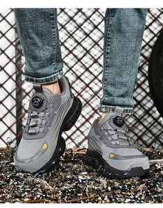Detail of grey safety shoe with mesh upper and rotary buckle system on industrial background
