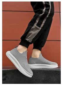 Outdoor-Aufnahme von grauen Herren-Slip-on-Sneakern aus Strick mit dicker weißer Sohle