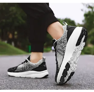 Detail van de ademende gebreide textuur en de dikke gedempte zool van de sportsneakers