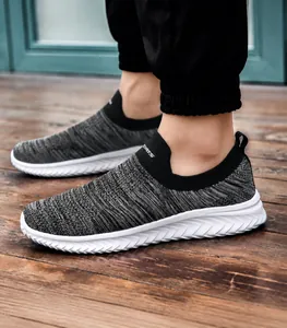 Side view of lightweight breathable grey knitted slip-on sneakers with white soles