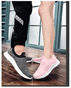Close-up of breathable knitted slip-on sneakers for couples in grey and pink colors