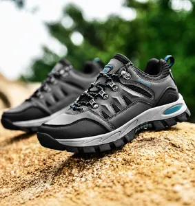 Nahaufnahme von Low-Top-Wanderschuhen mit Mesh-Obermaterial und Gummisohlen auf Felsen