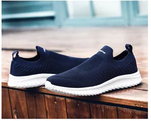 Detailed close-up of dark blue breathable knit slip-on sneakers with white sports logo