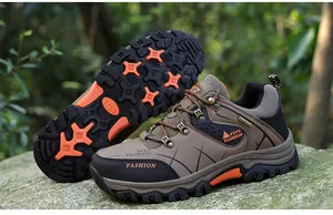 Rugged outdoor hiking shoe featuring a non-slip rubber sole with orange traction grips