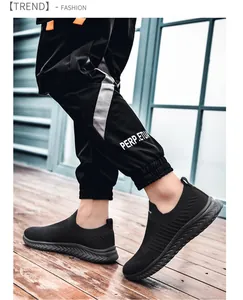 Outdoor shot of black breathable slip-on sneakers paired with printed jogging pants