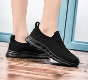 Detail of black breathable knit slip-on sneaker with anti-slip wave pattern outsole