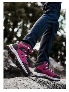 Magenta Wanderschuh mit griffiger Gummisohle beim Tritt auf Outdoor-Felsen im Wald
