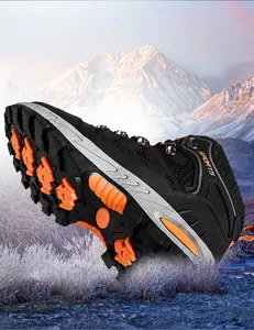 Dettaglio della suola arancione antiscivolo sulle scarpe da trekking nere outdoor