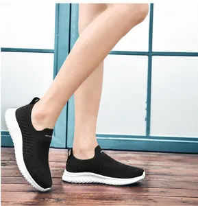 Detail shot of breathable black fly-knit slip-on sneakers with striped texture
